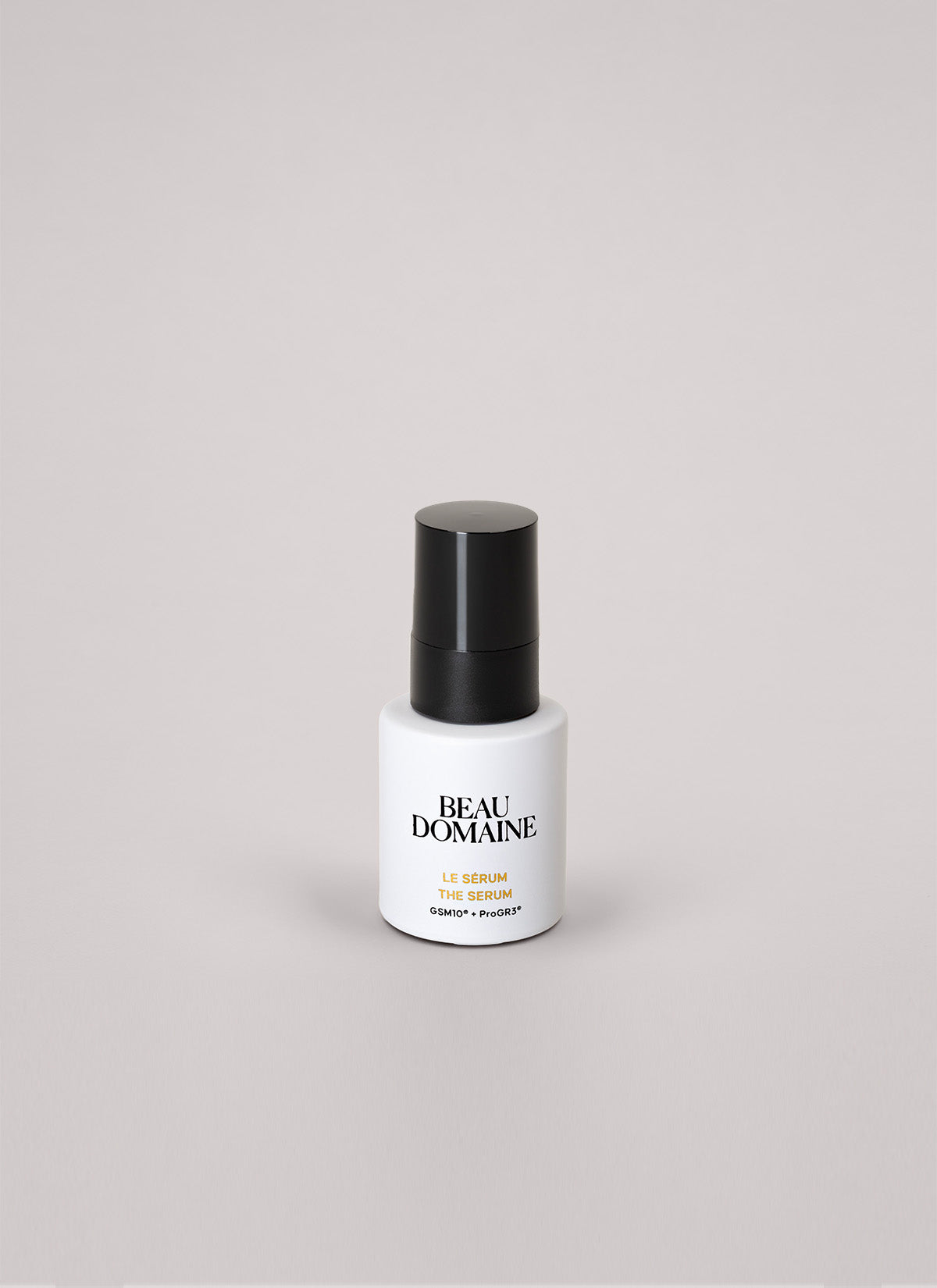 Frasco blanco de sérum con tapa negra sobre fondo gris claro